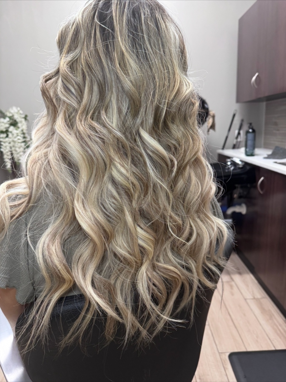Invisible bead extensions styled blonde waves back view
